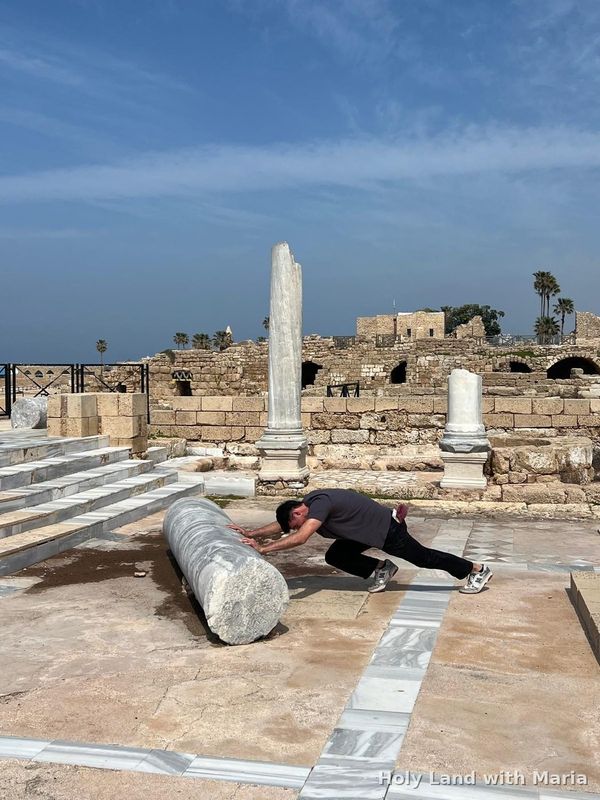A guest playing with a fallen Roman column at Caesarea