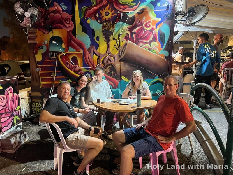 Guests on a Haifa food tour with Maria Lando eating in the Talpiot neighbourhood at night