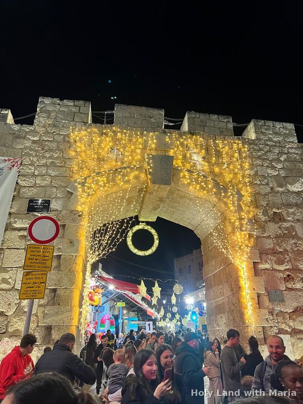 Crowds at the Christmas fair under the lights of the New Gate, Old City of Jerusalem