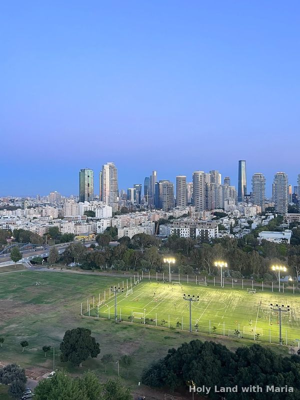 The Tel Aviv skyline at dusk seen across the sports fields