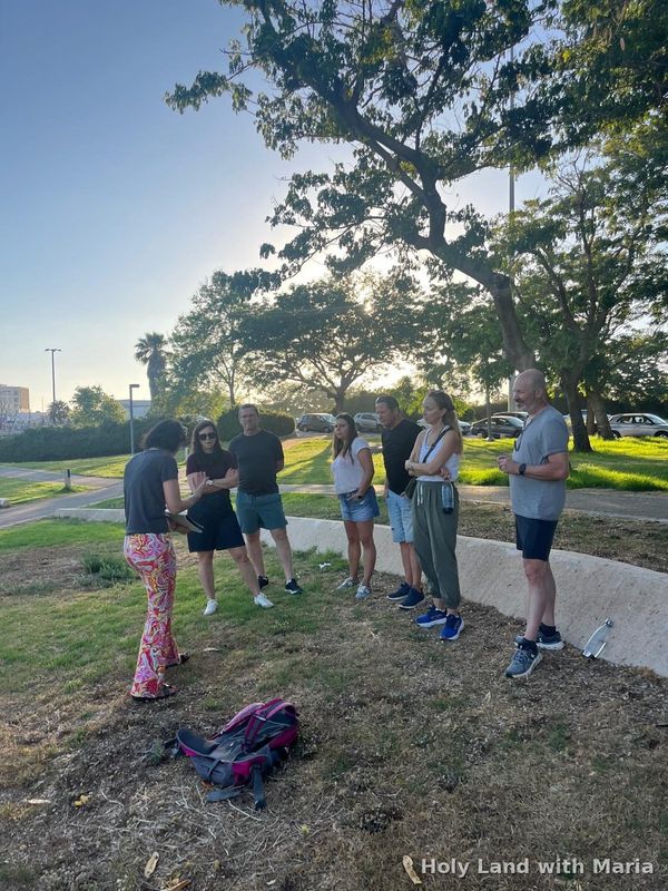 Tour group under a tree beside the Yarkon at dusk, Tel Aviv